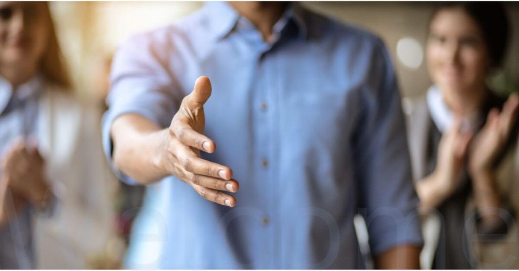 Someone reaching out to shake hands in introduction
