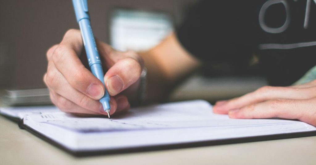 Picture of an arm as someone writes in a journal