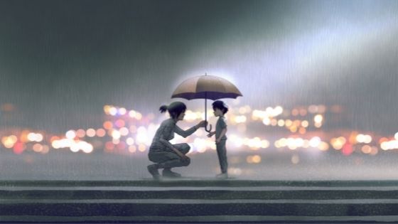 Woman squatting in the rain to hold her umbrella over a small, lost boy