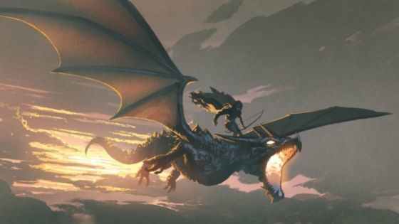 Rider on the back of a dragon flying at sunset